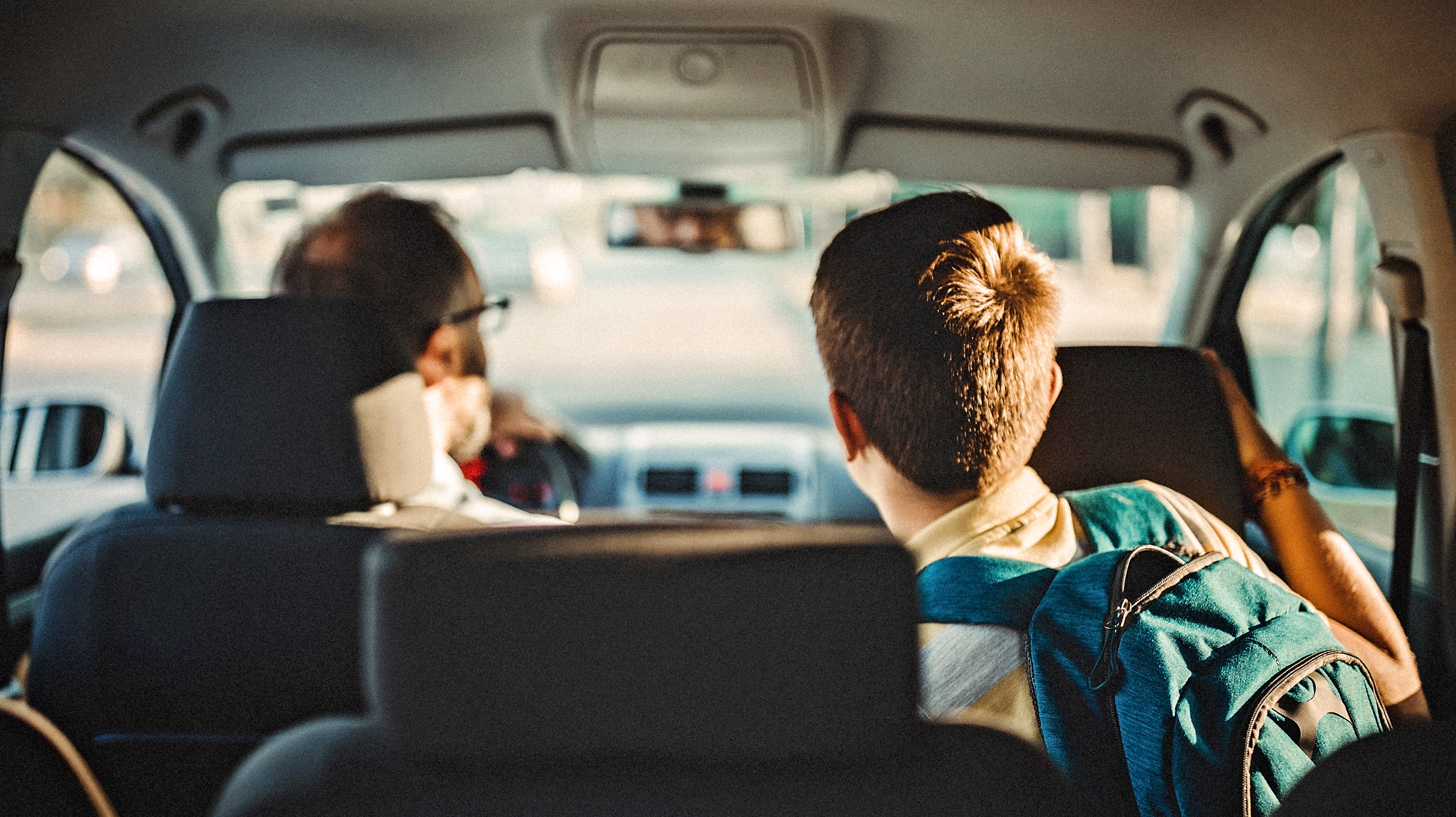 Drive back. Children in the back Seat of the car. Go to School by car. Car back view in the Road to School. Car from back near.